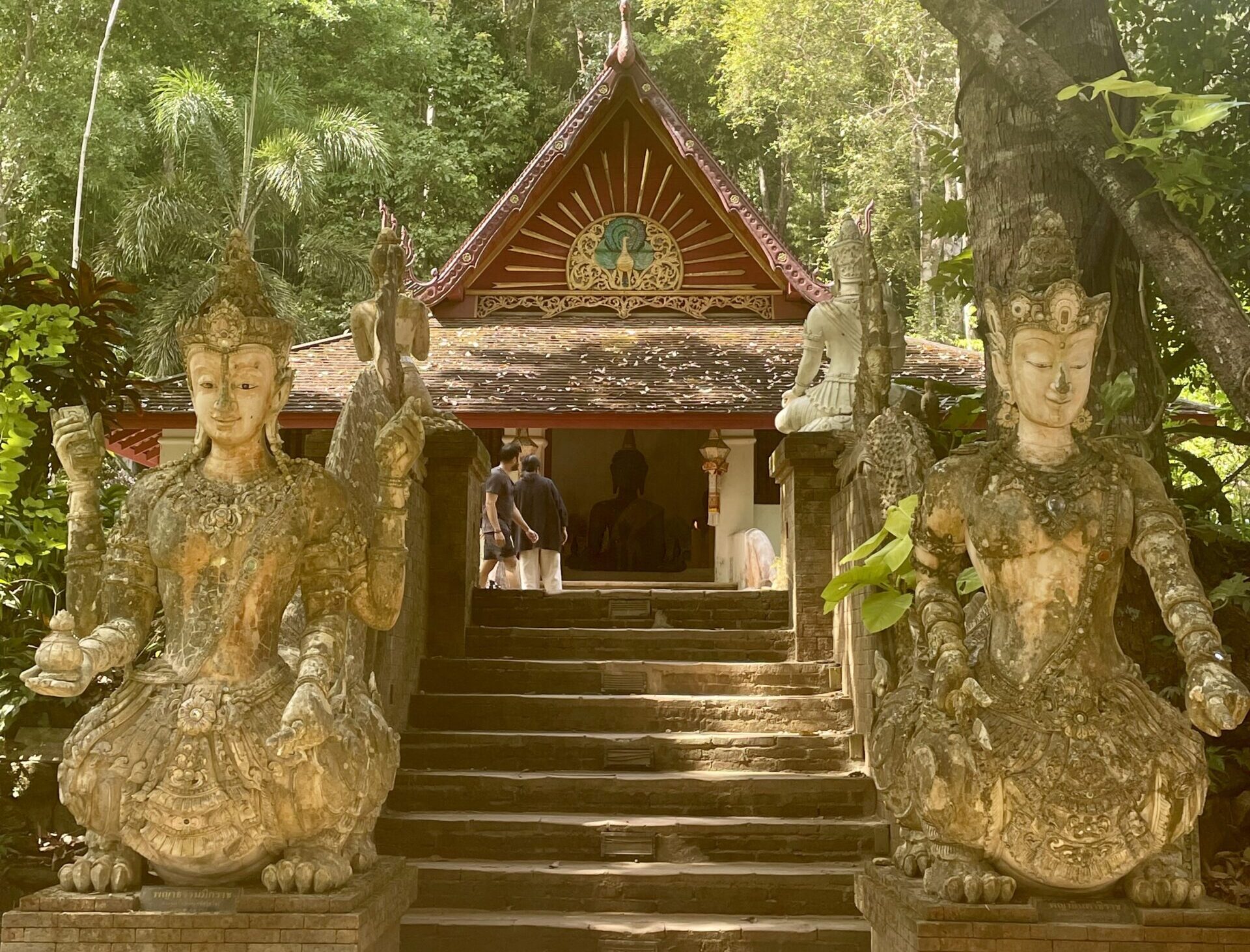 Wat Pha Lat Eine Treppe, geziert von zwei steinernen Statuen führt hinauf zu einem Tempelgebäude des Wat Pha Lat.